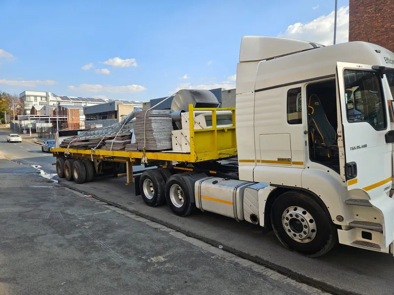 Flatdeck trailer loaded with structural steel roofing materials