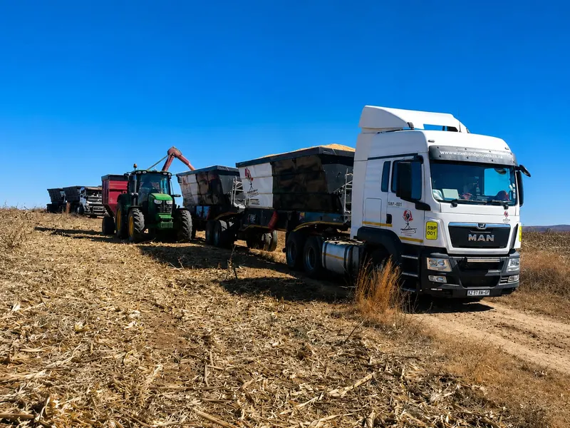 SteelBand Projects truck towing a tractor and side tipper trailers in a field